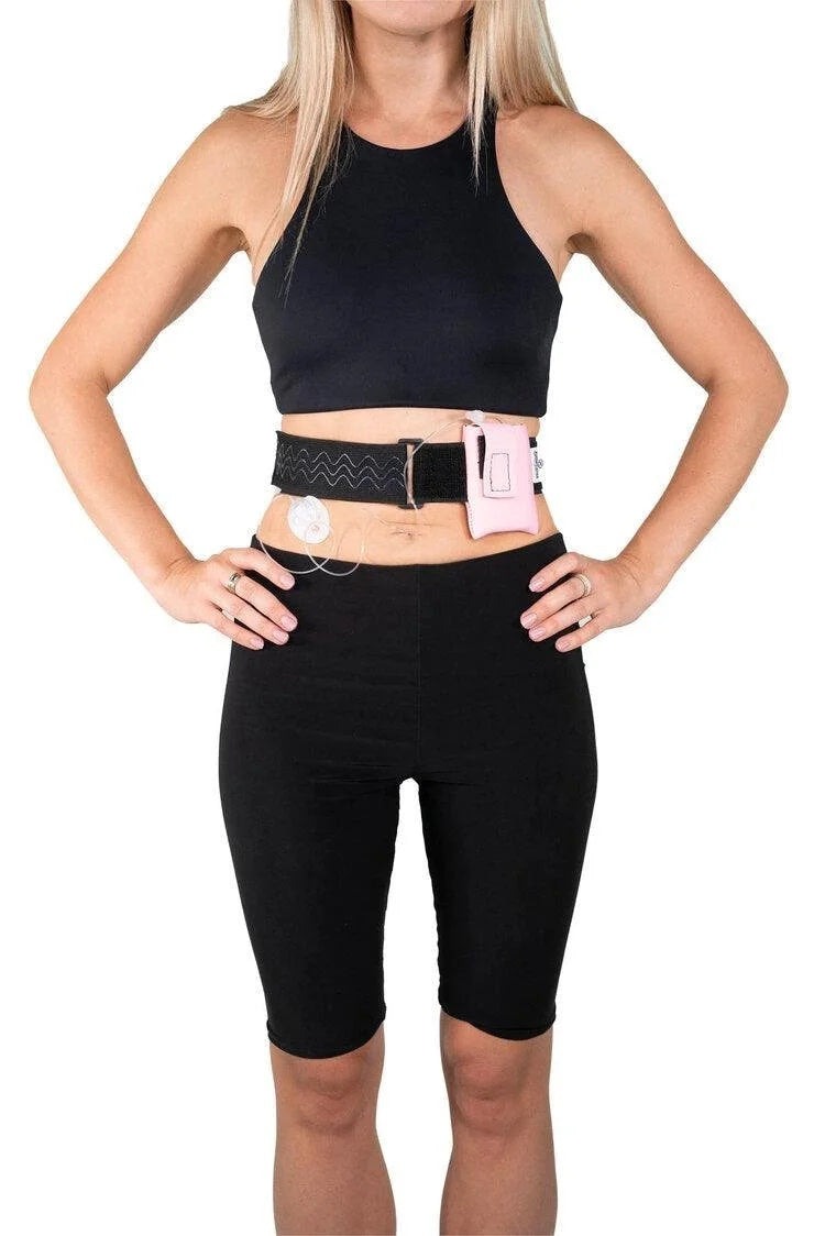 A woman wearing a Pumpcases rose pink waist belt case on a white background.