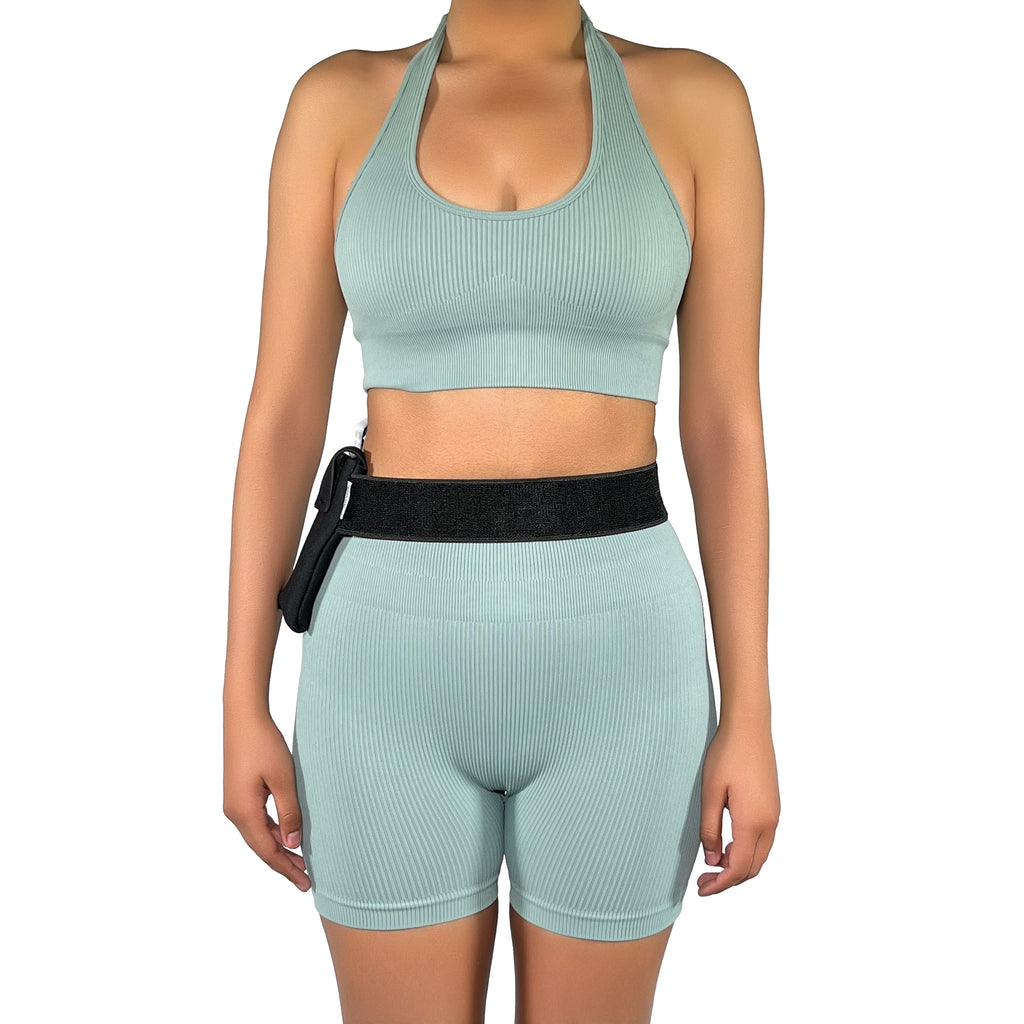 A woman wearing a Pumpcases Omnipod 5 PDM black waist belt case on a white background.
